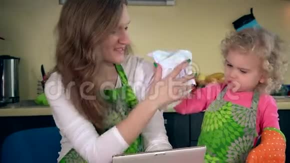 玩的妈妈和小帮手在厨房玩平板电脑视频的预览图