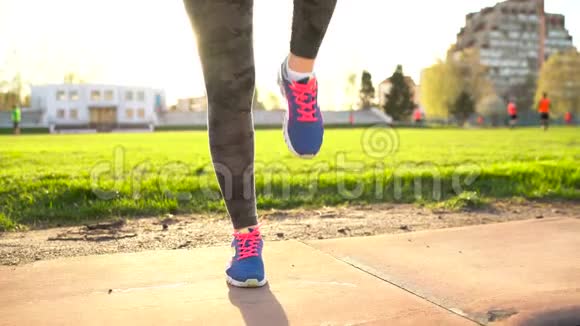 日落时分女人在体育场慢跑前做热身运动视频的预览图