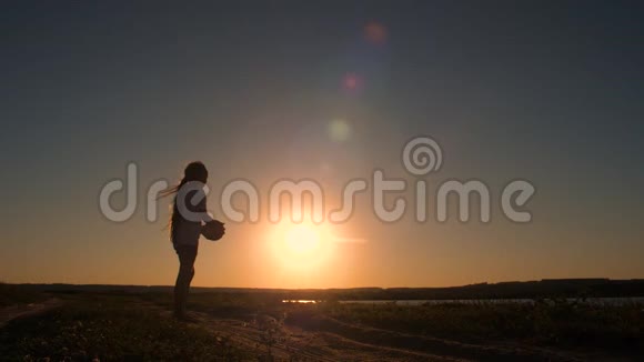 少女抛球向上日落慢动作视频的预览图