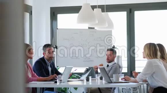 商务人员在办公室开会时一起在会议室讨论视频的预览图