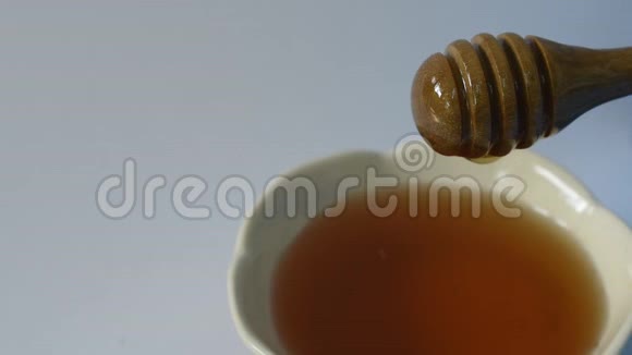 白色背景下木勺上的蜂蜜视频的预览图