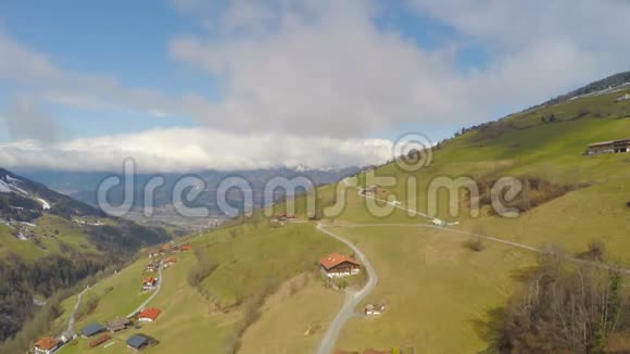 空中景色绿色的农村地区农民的房子山上的道路多云的天空视频的预览图
