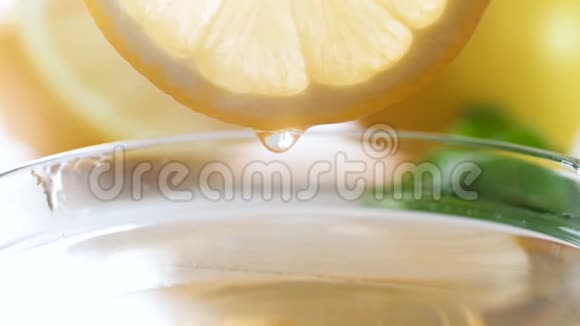 在茶杯中的柠檬片中慢慢滴出果汁的慢速镜头视频的预览图