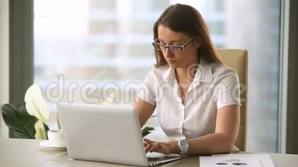 厌倦了忙碌的女商人在手提电脑上工作对文件有问题视频的预览图
