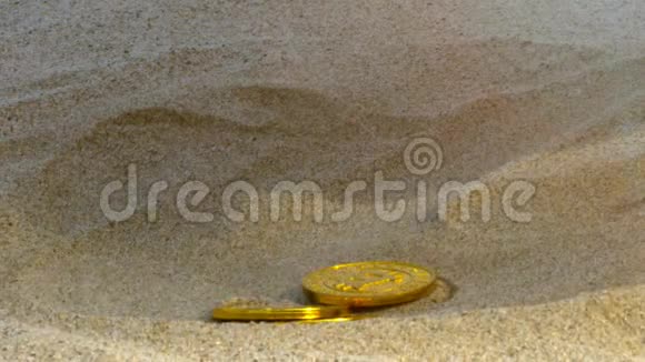 女孩的手把金色的比特币扔进海滩沙坑关闭宏观视频的预览图