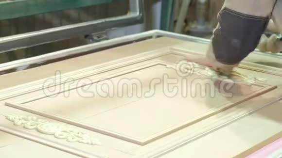 一个人一个工人从灰尘中清理一个木制的空白一扇门生产室内木门视频的预览图
