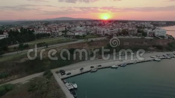 日落时飞过码头和屋顶NeaKallikratia希腊视频的预览图