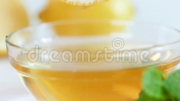 特写慢镜头用蜂蜜将柠檬片浸入玻璃瓶中视频的预览图
