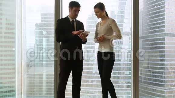 商人和女商人在与全长窗户的会面中握手视频的预览图
