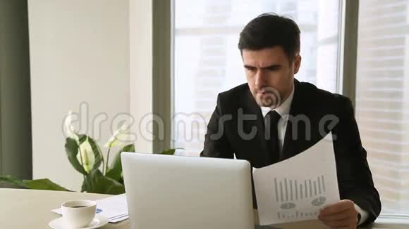 愤怒的忧心忡忡的商人在笔记本电脑上工作对文件有问题视频的预览图