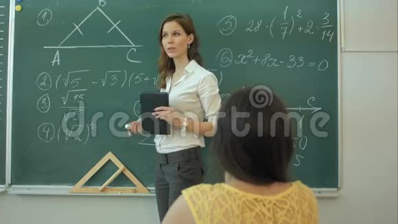 聪明自信的女学生在教室里用黑板写数学视频的预览图
