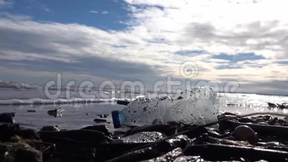 塑料瓶上的湿沙被海浪抛出来视频的预览图