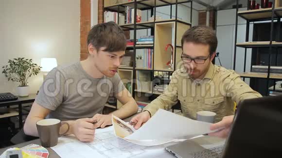 两位工程师正在看坐在桌子旁的蓝图视频的预览图