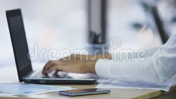 在办公室工作的混血女商人用手提电脑打字双手特写视频的预览图