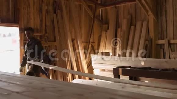 工人在木制品加工设施里拿起木板用木工连接机视频的预览图