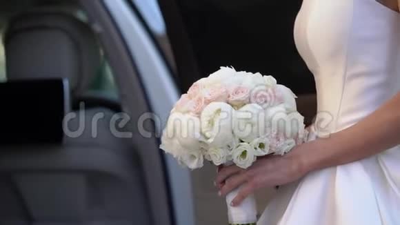 年轻的新娘穿着婚纱在城市里捧着花束白色豪华礼服视频的预览图