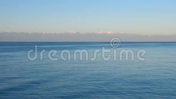 伊塞克库尔湖蓝色平静的水背景是群山视频的预览图