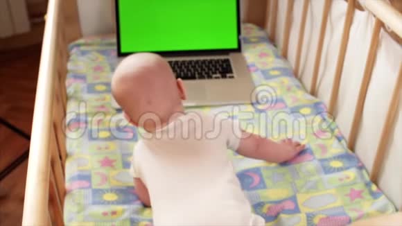 可爱的小男孩在笔记本电脑上用彩色屏幕快速旋转视频的预览图