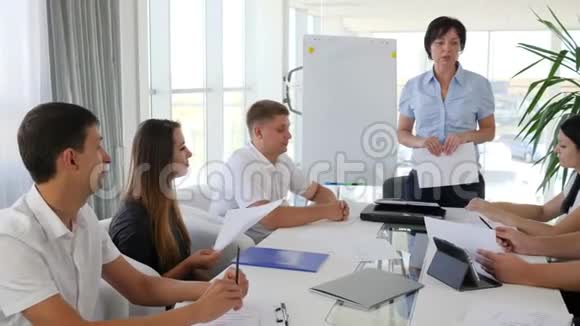 女导师拿着文件讨论商业发展的想法和合作者的办公室视频的预览图