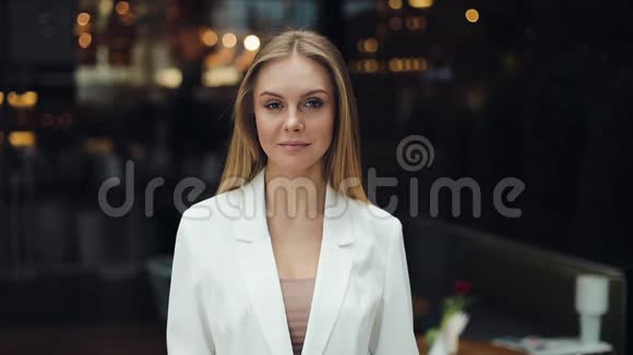 漂亮的金发女人直视着站在购物中心的镜头视频的预览图
