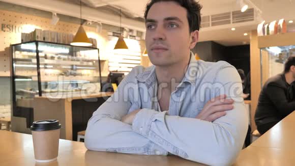 放松年轻人坐在咖啡馆里视频的预览图
