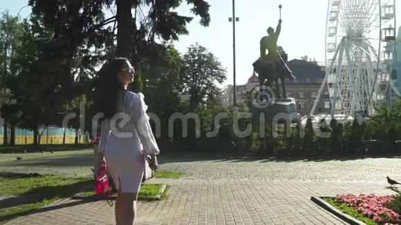 时髦的黑发少女在美丽的早晨公园散步视频的预览图