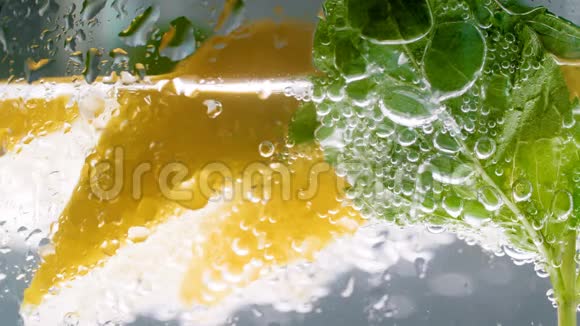 新鲜冷柠檬水柠檬和薄荷杯中气泡的宏4k视频视频的预览图