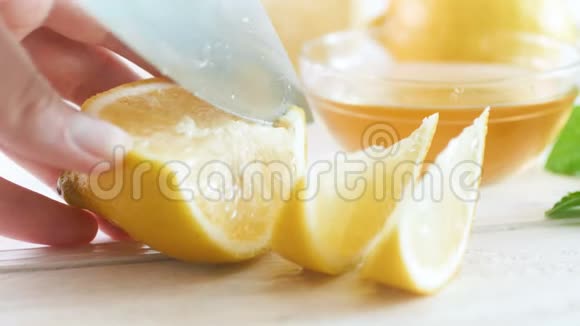 特写4k视频女性手切新鲜柠檬柠檬水在白色木桌上视频的预览图