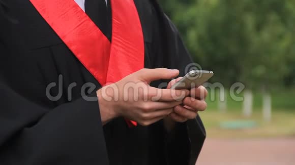 大学毕业生在智能手机上浏览新闻男大褂在滑动页视频的预览图