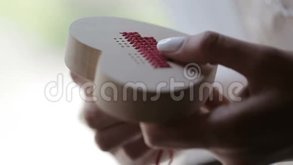 女人心中的木箱上绣着红线手的特写镜头视频的预览图