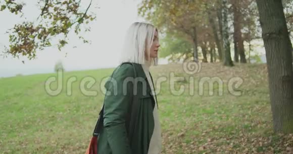 中弹白种人金发女人斯洛莫走过秋天的树林摸着树跟着边框讲故事视频的预览图
