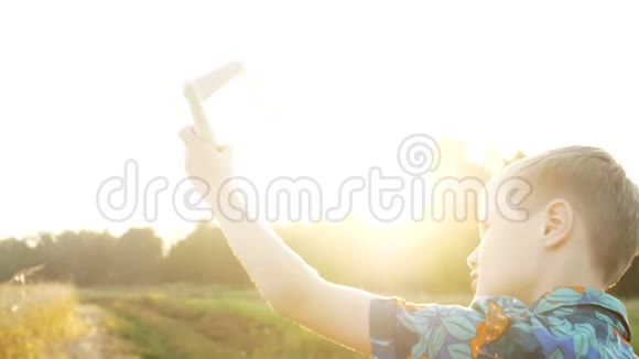 日落时一个男孩玩一架模型飞机梦想成为飞行员视频的预览图