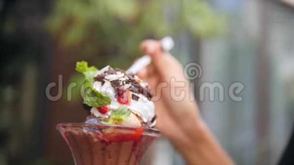 年轻的混血女孩喜欢在咖啡馆吃健康的巧克力香草草莓薄荷冰淇淋特写女性手视频的预览图