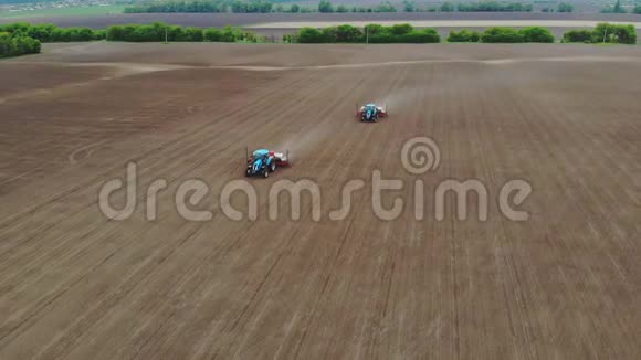 空中勘测俯视图春天有两台拖拉机在田间用专用的精密播种机种植玉米视频的预览图