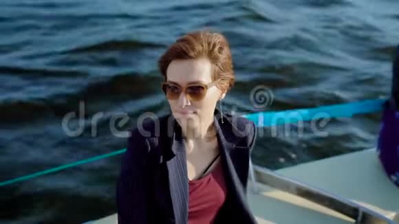 年轻的红发女郎坐在船甲板上享受着最后一个夏天的时刻视频的预览图