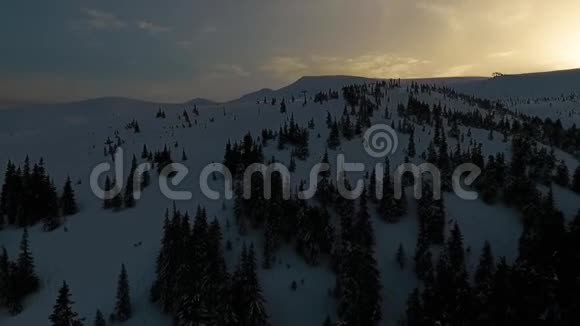 在雪覆盖的德拉戈布拉特山上用针叶林和滑雪缆车进行空中射击视频的预览图