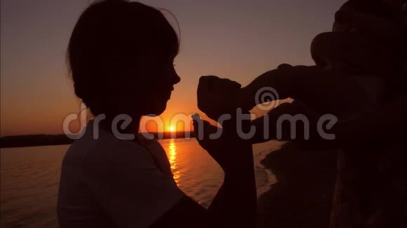 一个婴儿和十几岁的孩子正在日落时玩耍慢动作视频的预览图