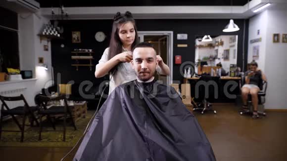 理发的过程前景男潮客和女理发师理发店内部景观视频的预览图