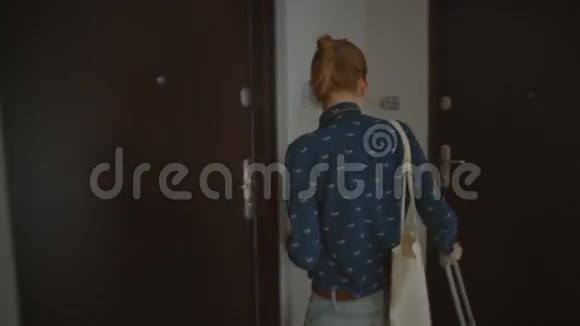 年轻的苗条女士游客正在打开大门进入公寓与西装革履视频的预览图
