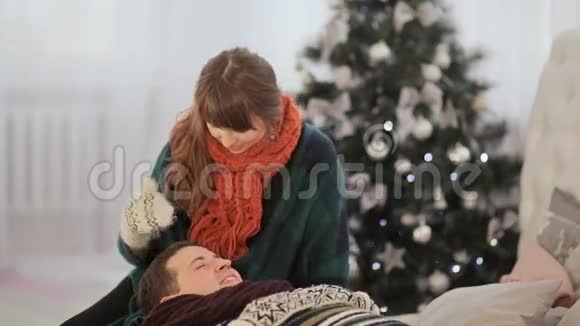 一对相爱的夫妇躺在床上一个女孩抚摸着她男朋友的头温暖的平安夜视频的预览图
