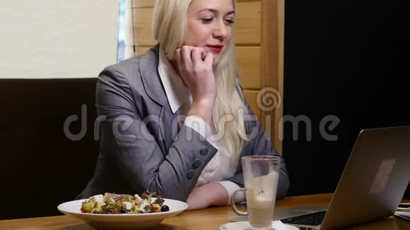 商务女性在咖啡厅的笔记本电脑视频链接上发言视频的预览图