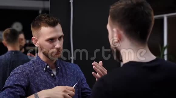 男性时髦的顾客和男性理发师交谈和交流视频的预览图