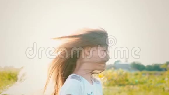 一个迷人的小女孩长着一头飘逸的长发她的头向不同的方向转动风吹起了长发视频的预览图