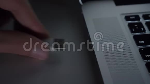 特写镜头的男性手快速插入USB电缆到笔记本电脑的黑桌背景视频的预览图