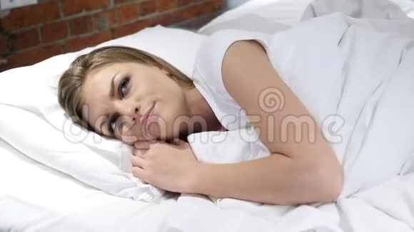 躺在床上思考和想象夜晚的女人视频的预览图