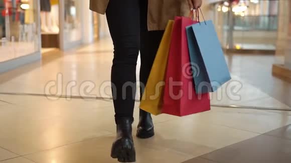 看看一个女人带着购物袋在商场里走来走去的腿视频的预览图