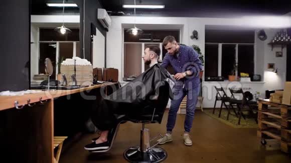 理发店时尚发型的创造理发师和男性客户室内景观视频的预览图