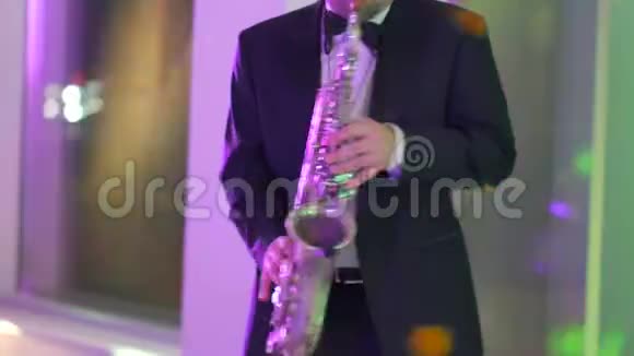 穿着夹克的萨克斯演奏家在金色萨克斯管上演奏视频的预览图