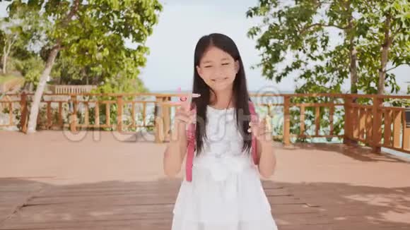 一个菲律宾的小女生展示了纺纱机热带景观夏天童年视频的预览图