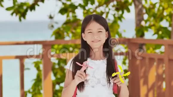 一个菲律宾小女生展示了纺纱机热带景观夏天童年视频的预览图